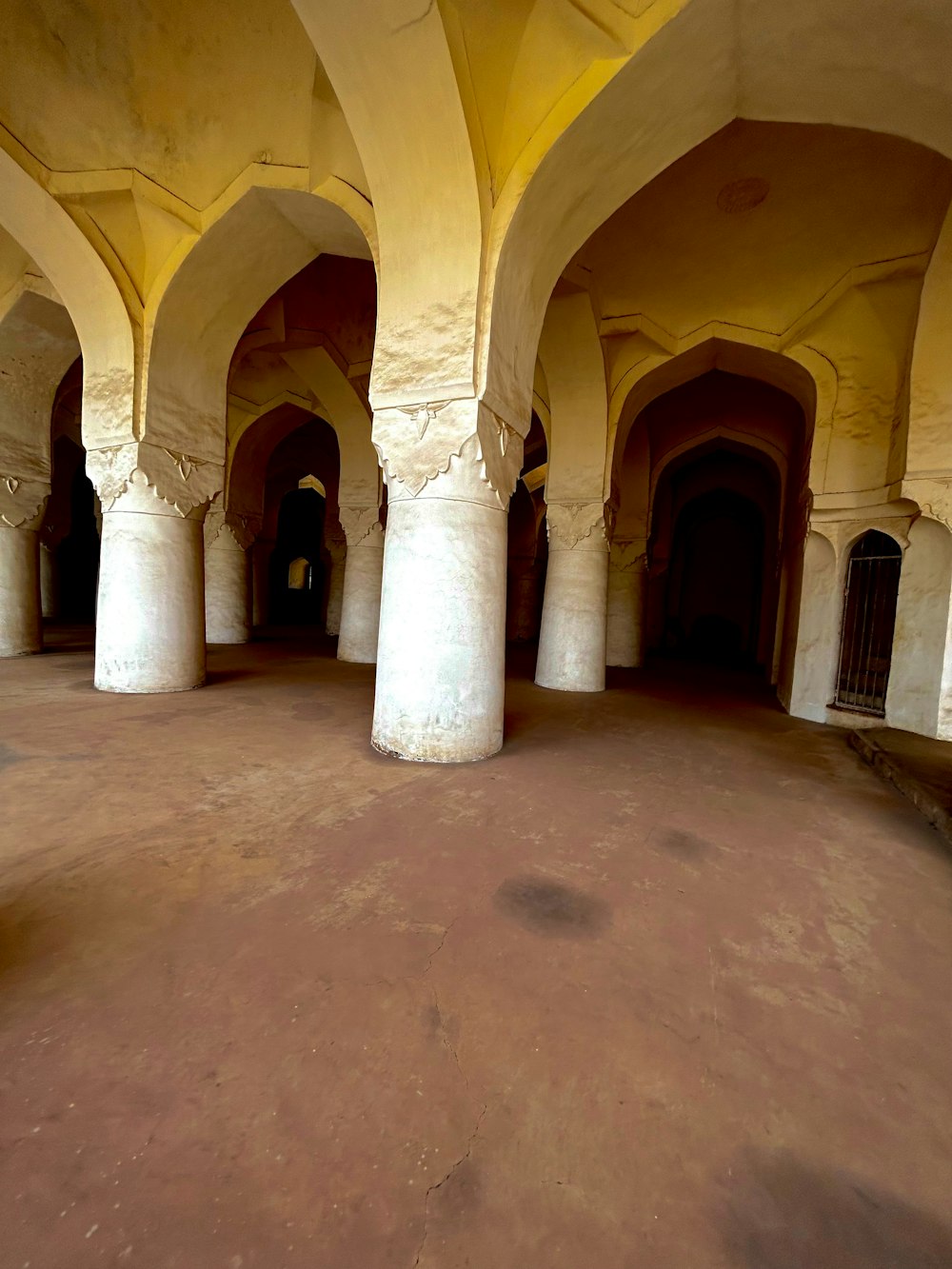 a large room with columns and a clock on the wall