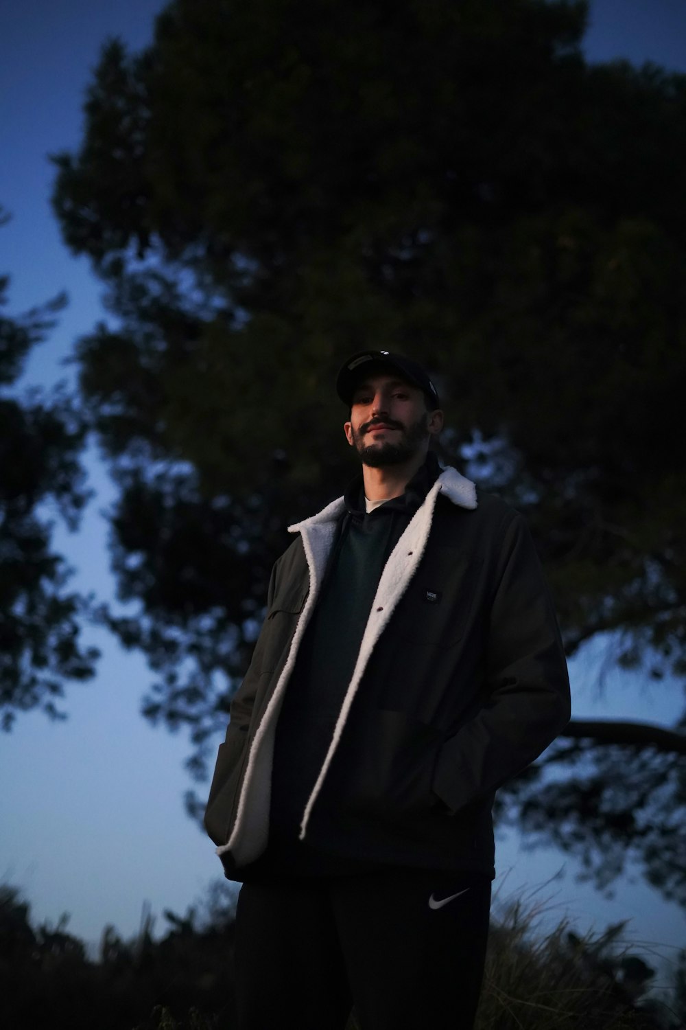 a man standing in a field with trees in the background