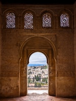 an archway with a view of a city in the distance