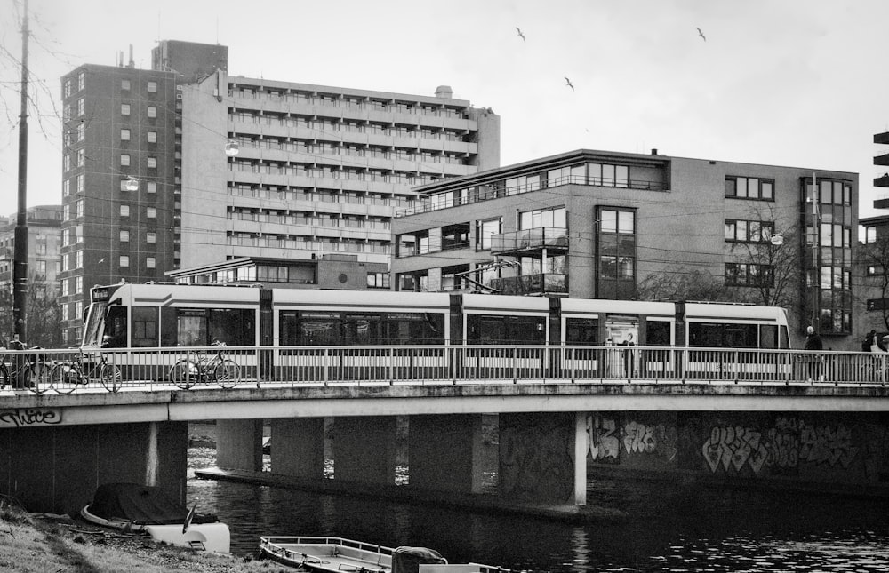 a black and white photo of a train on a bridge