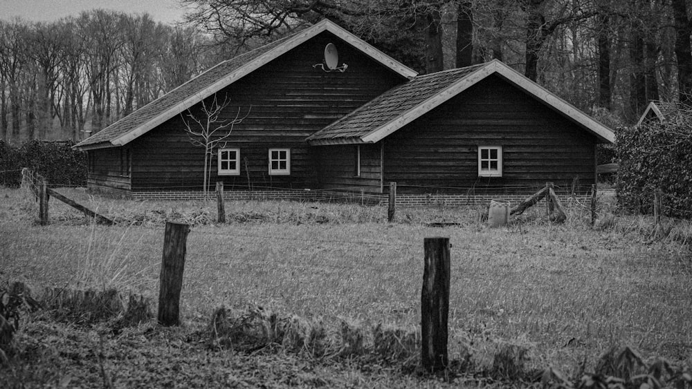 a black and white photo of a house in the woods