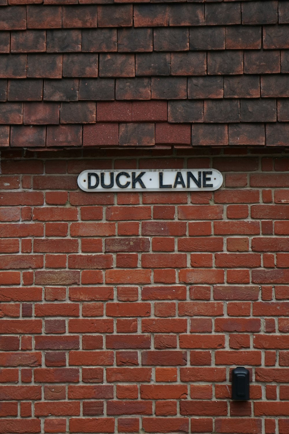 a brick wall with a street sign on it