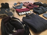 a pile of clothes sitting on top of a wooden floor