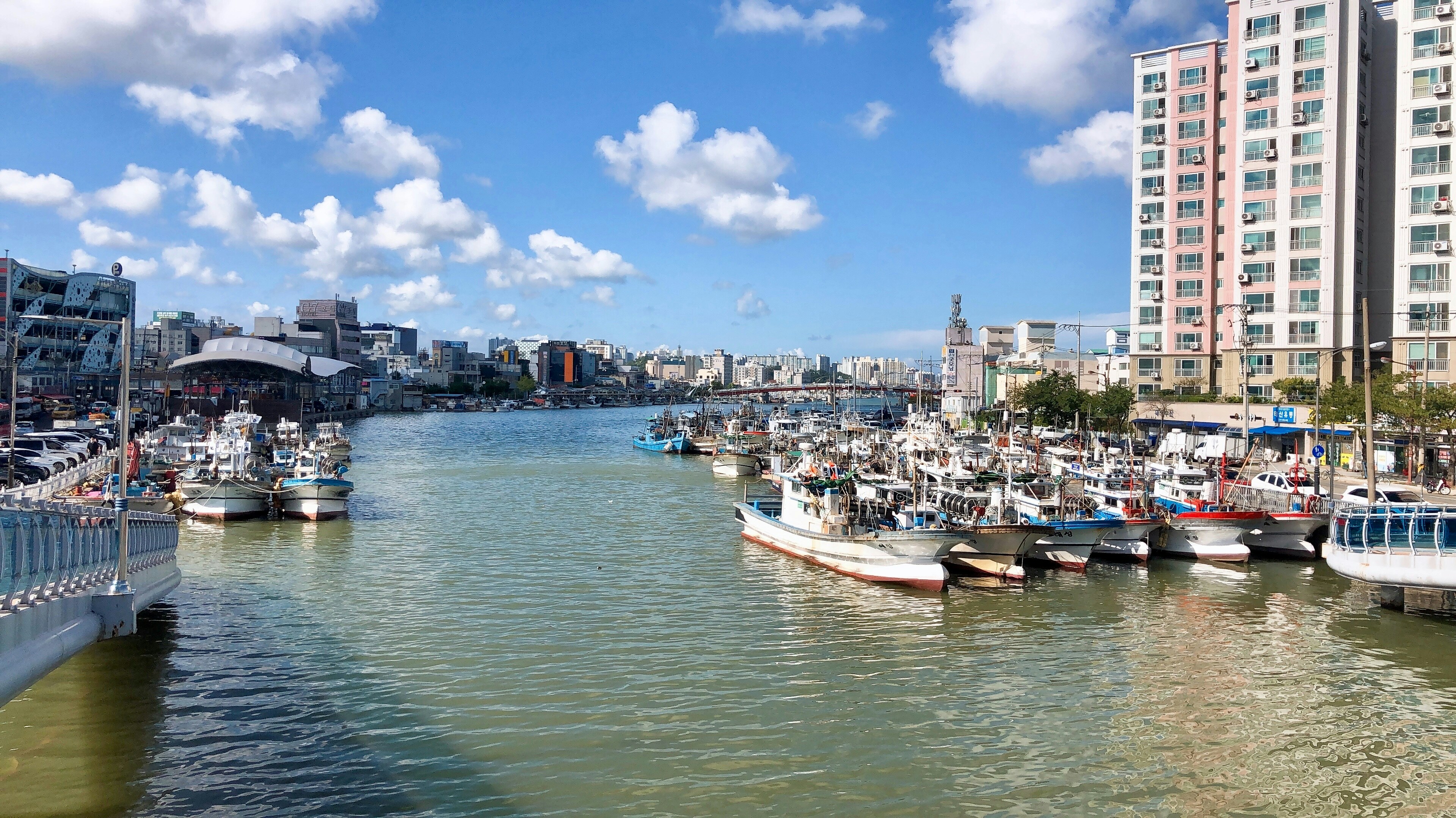 a harbor filled with lots of boats next to tall buildings