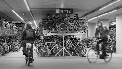 a woman riding a bike past a bunch of bikes