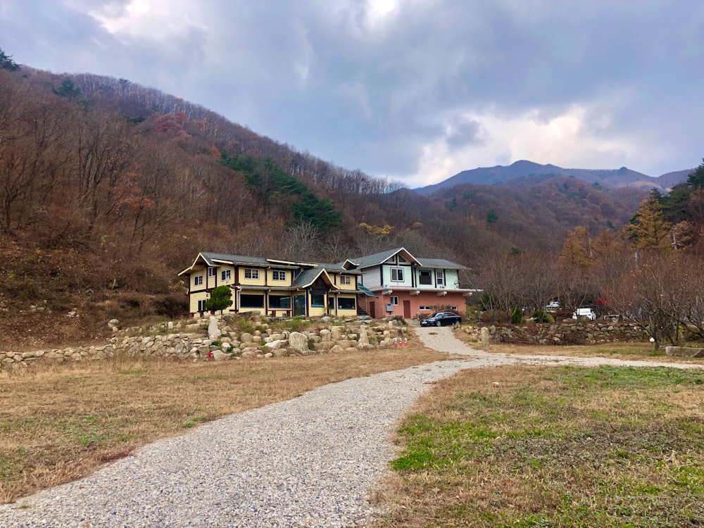 a house in the mountains with a gravel path leading to it