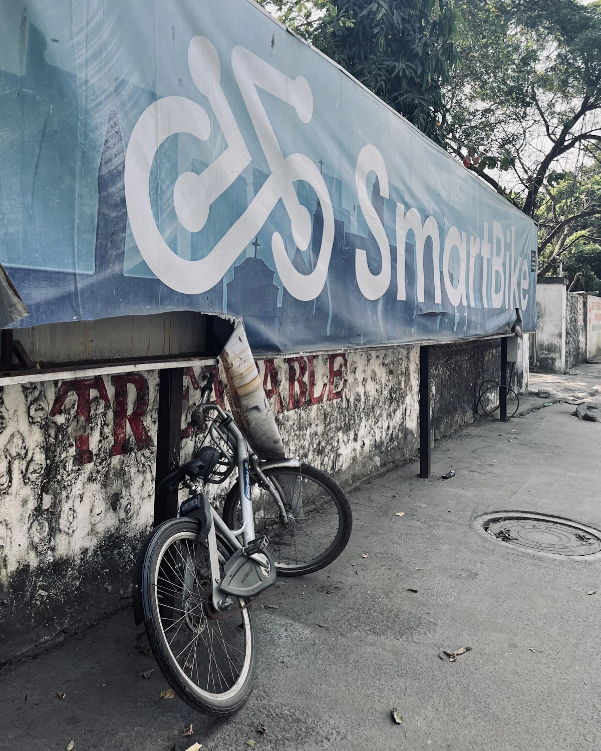 Indian street wall with large painted signage and hoarding next to a parked bicycle