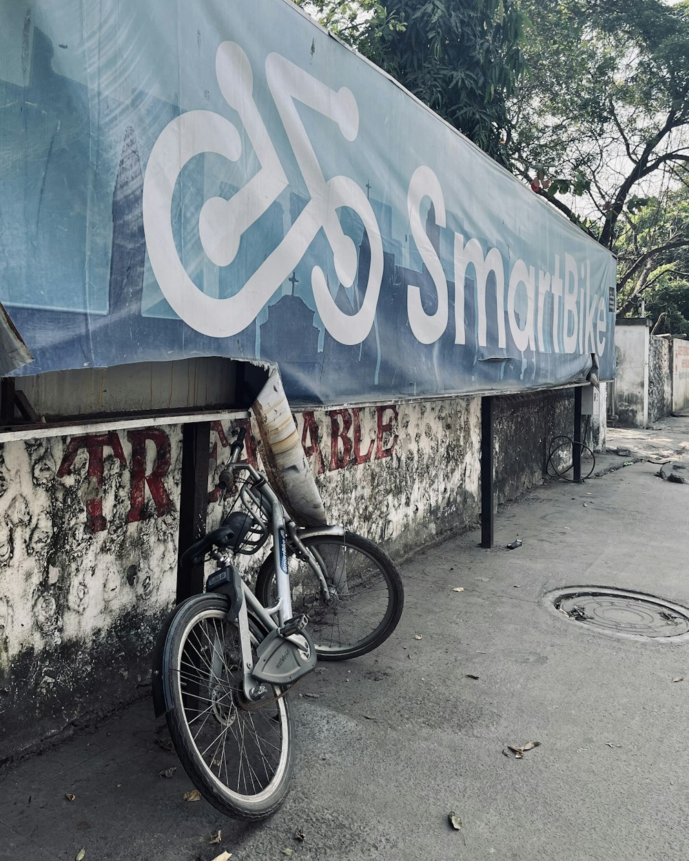 a bike parked next to a wall with a sign on it