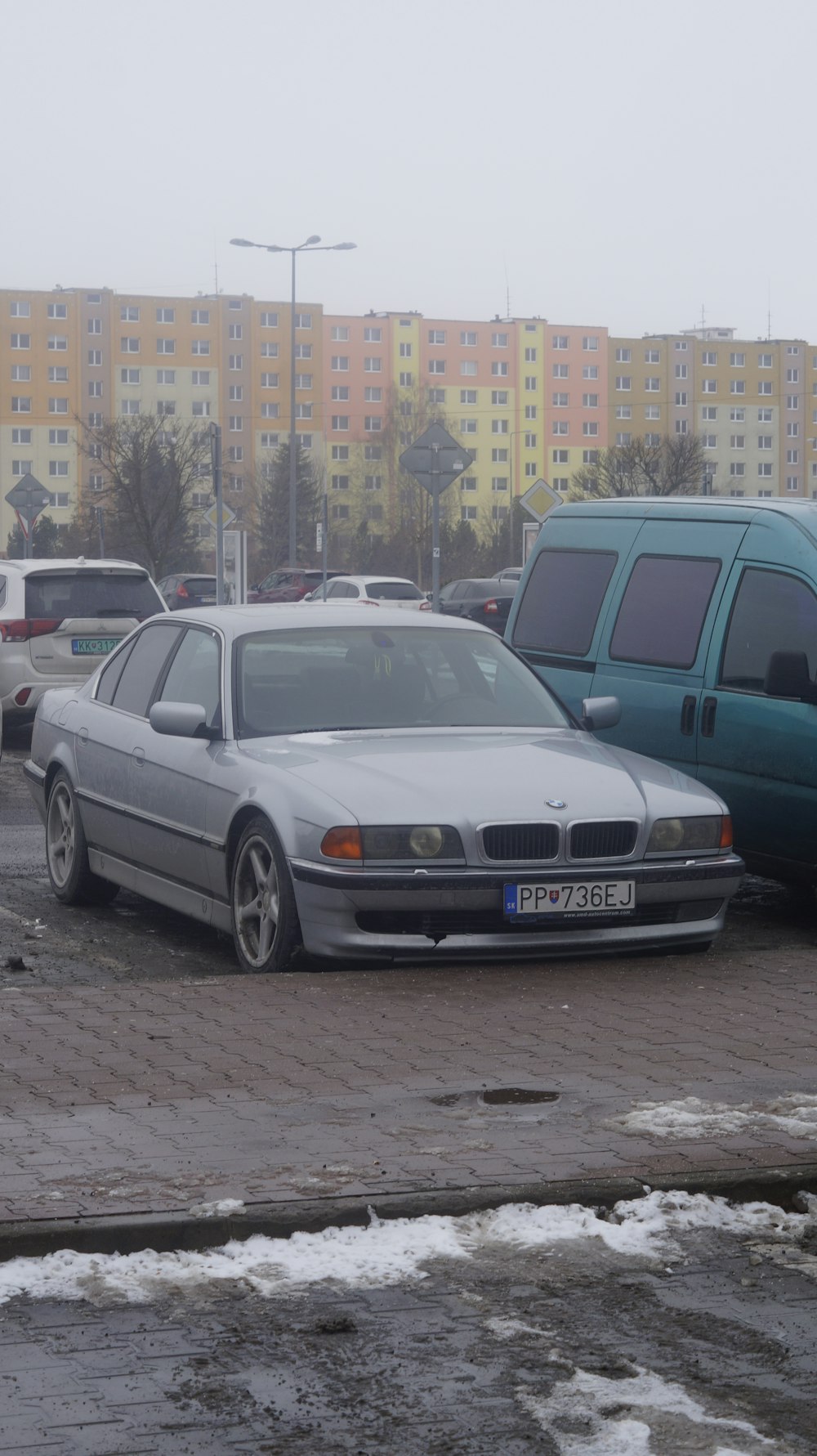 a silver car parked in a parking lot next to other cars