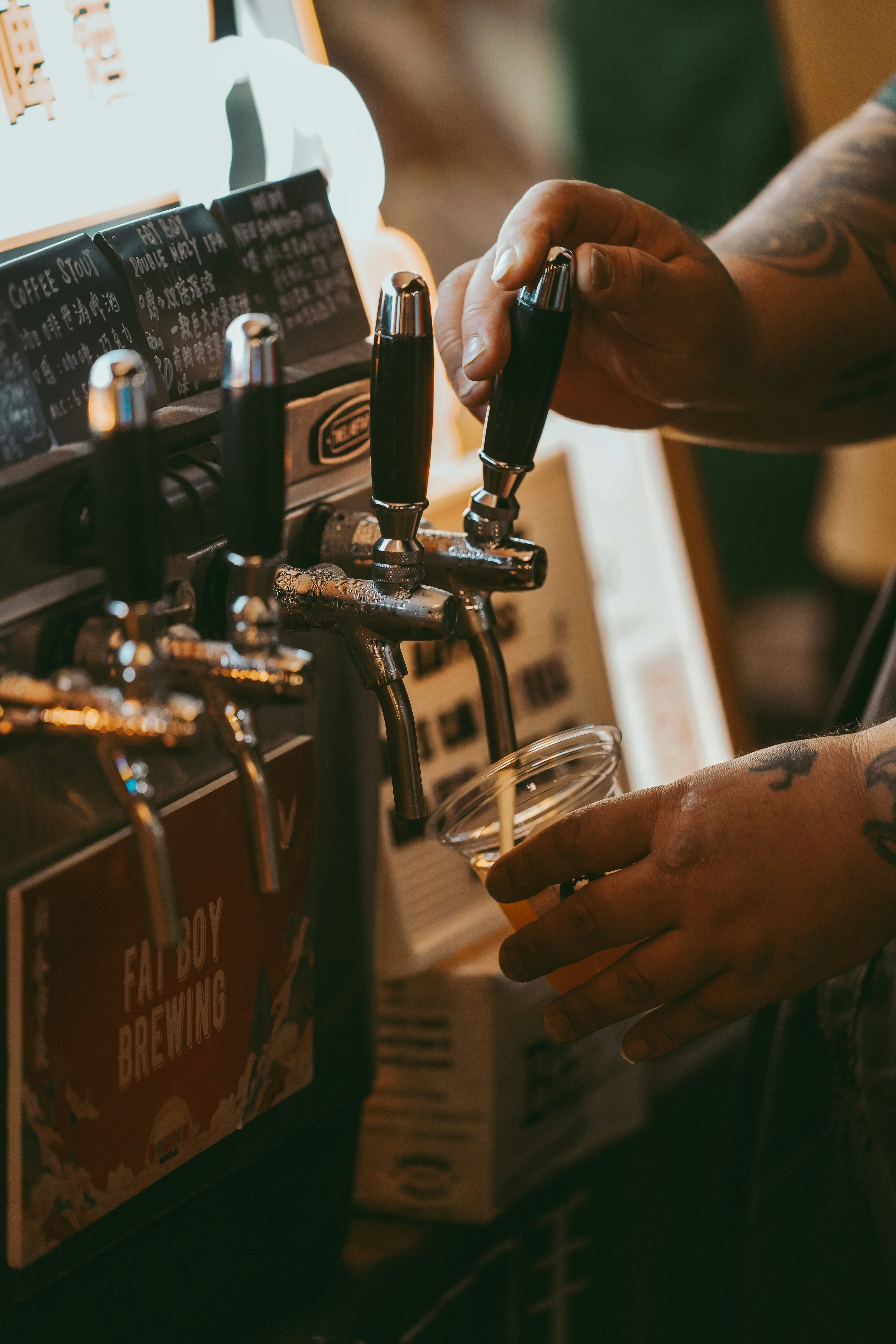 a person is filling a glass of beer