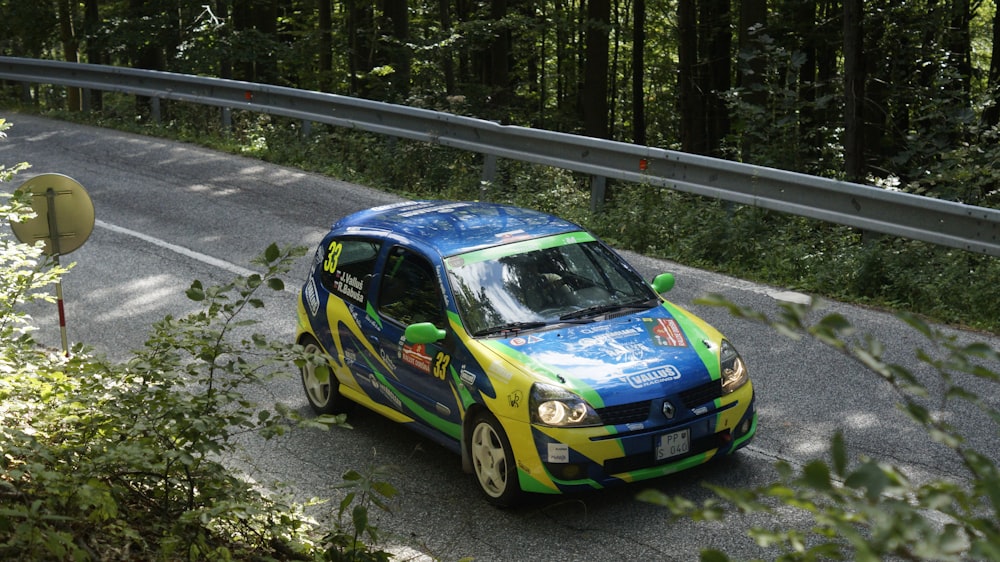 a blue and yellow car driving down a road