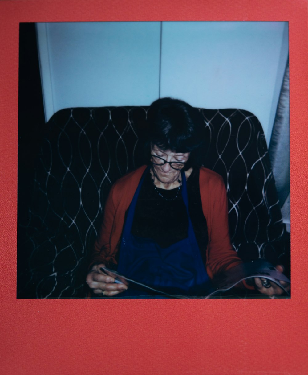 a woman sitting in a chair reading a book