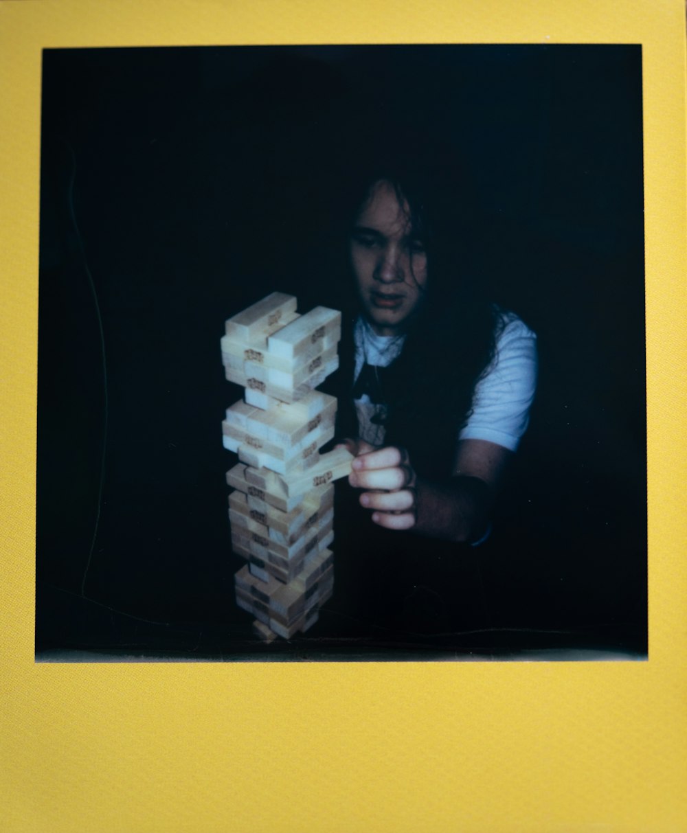 a man is playing with a stack of blocks