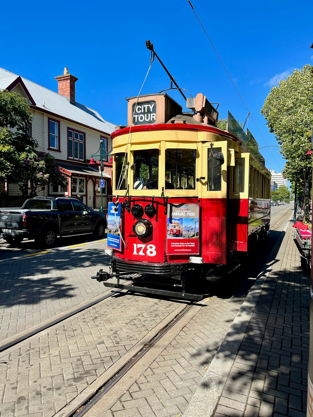 a red and yellow trolley car traveling down a street