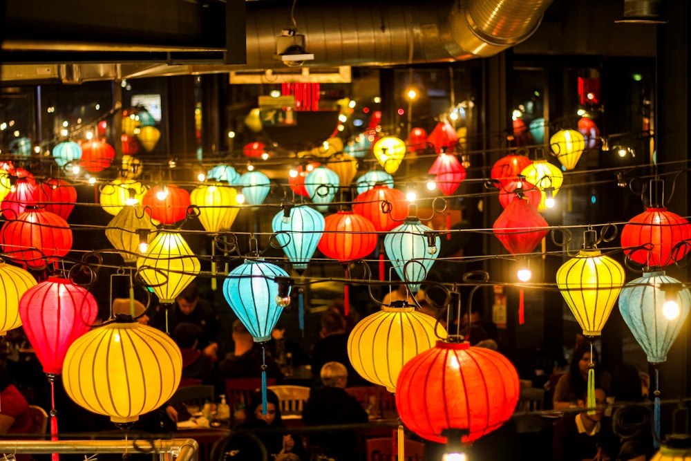 a bunch of colorful lanterns hanging from a wire