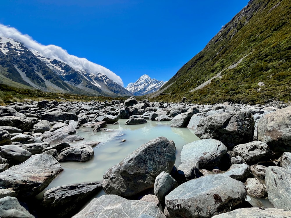 a river running through a rocky valley surrounded by mountains