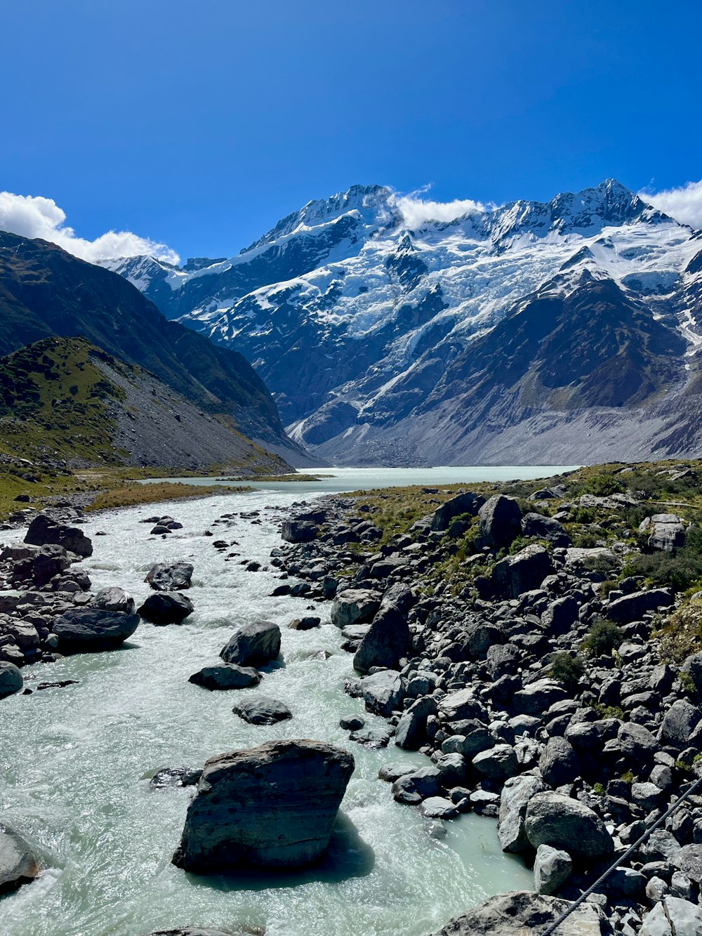 a river running through a valley surrounded by mountains