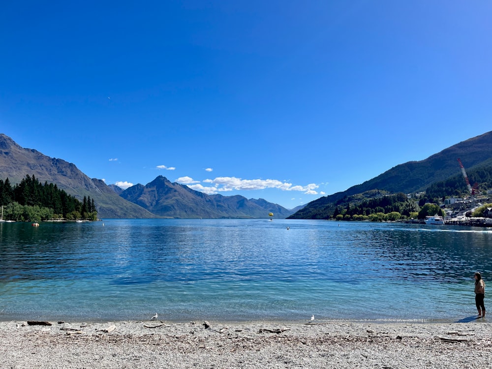 a person standing on the shore of a lake