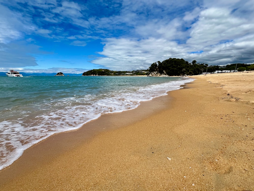 a sandy beach with a boat in the water