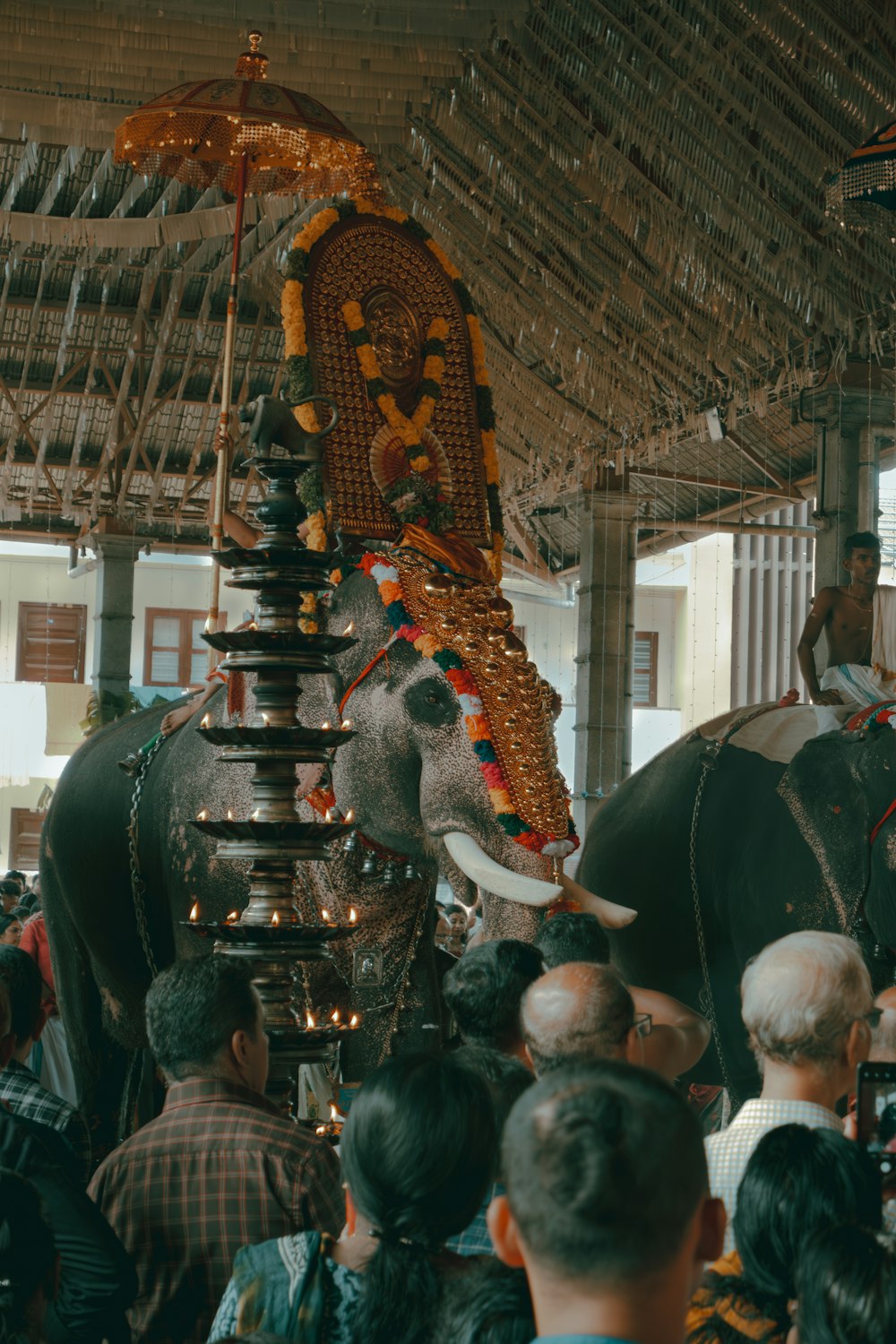 un gruppo di persone in piedi intorno a un elefante decorato