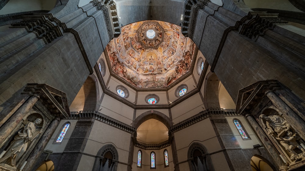 the inside of a church with a dome and stained glass windows