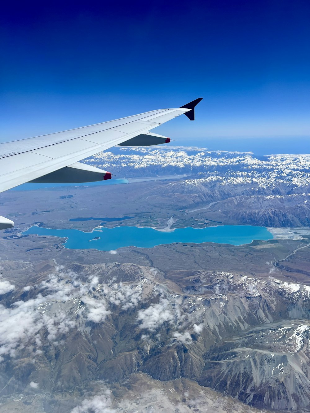 the wing of an airplane flying over a mountain range