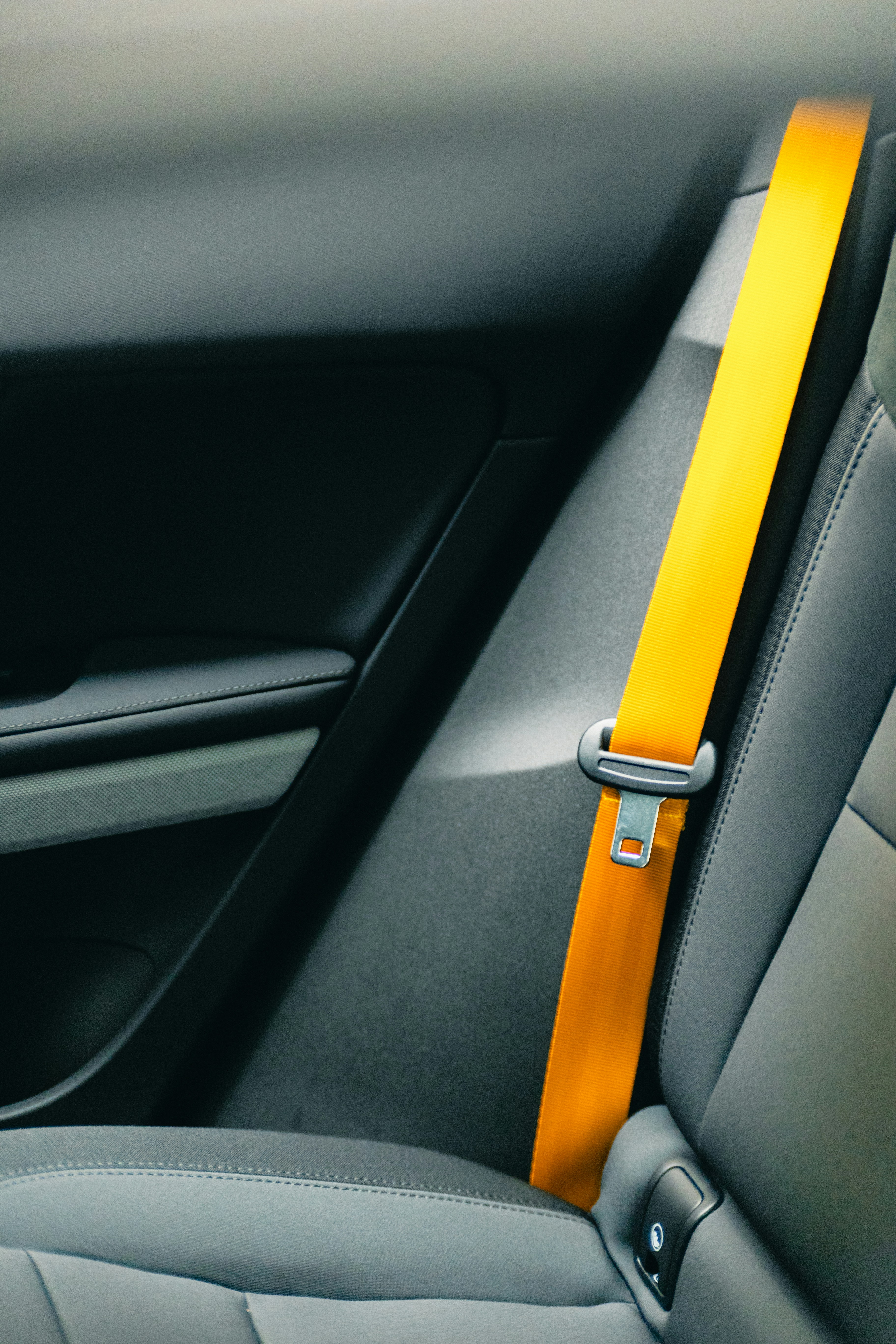 a close up of a car's interior with a yellow seat belt