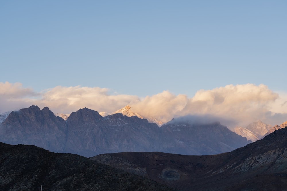 a view of a mountain range with clouds in the sky