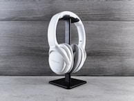 a pair of white headphones on a black stand