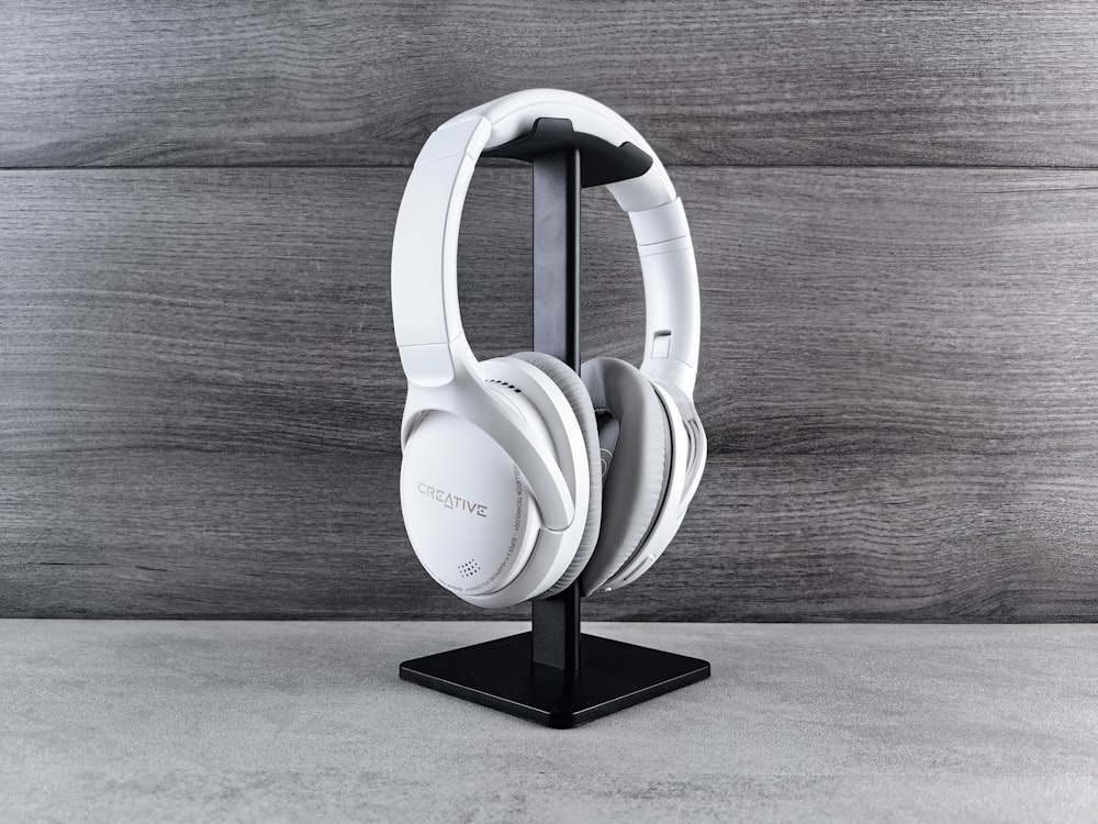 a pair of white headphones on a black stand