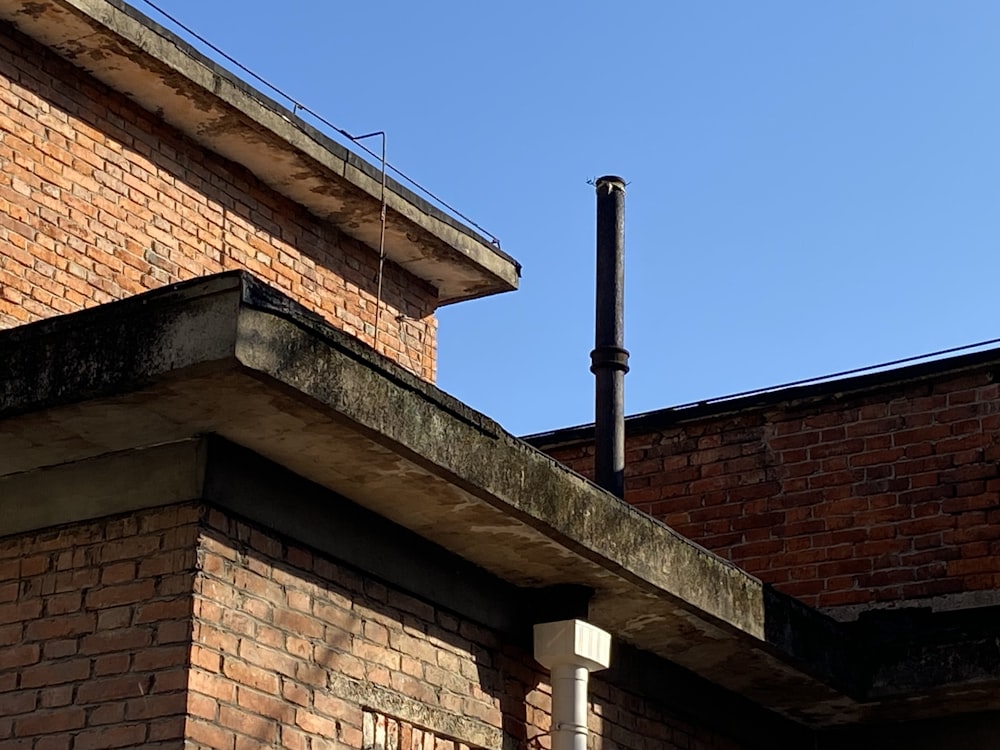 a brick building with a black pipe sticking out of it