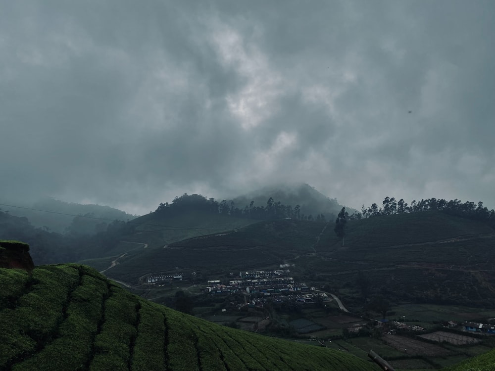 a cloudy sky over a lush green hillside