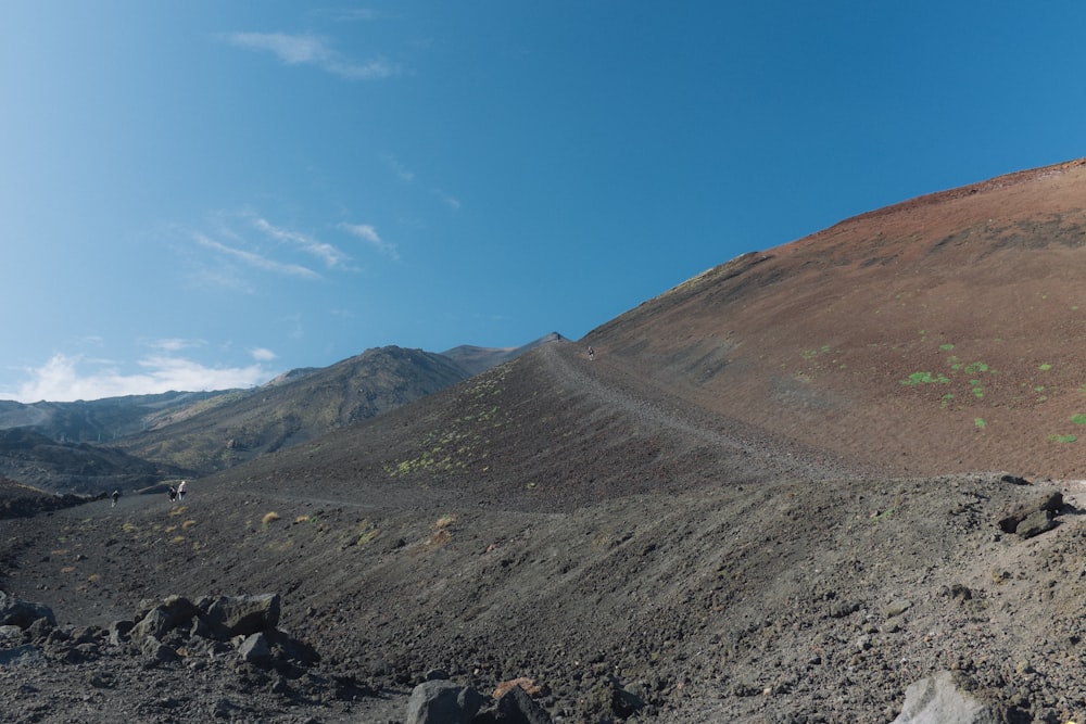 a dirt hill with a blue sky in the background