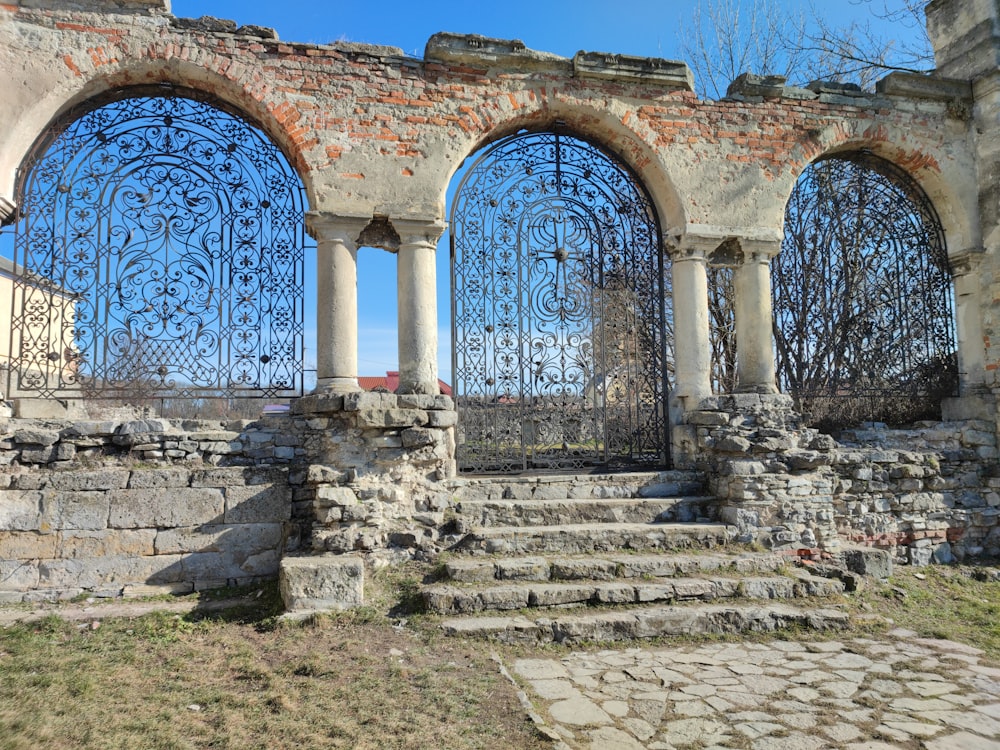 a stone building with four arched windows and a stone walkway