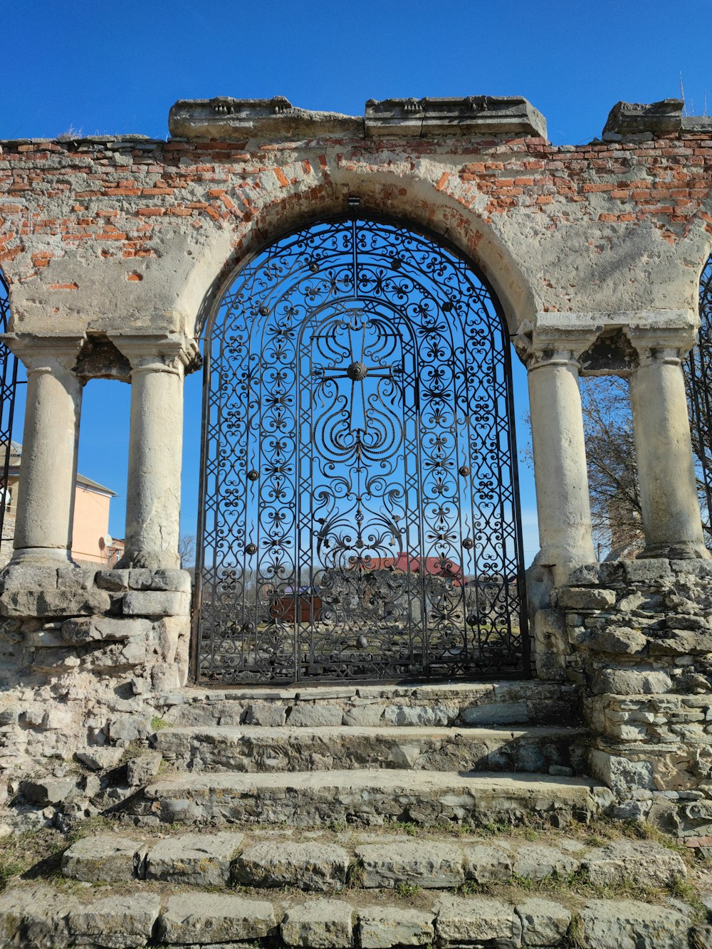 una puerta de piedra y hierro con escalones que conducen a ella
