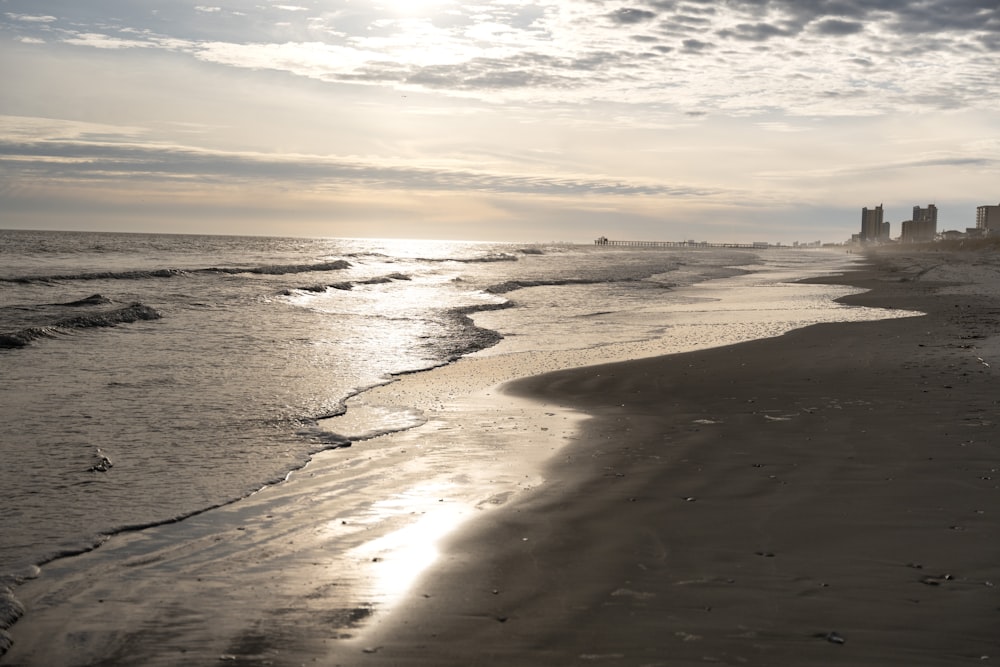 the sun is shining on the beach and water