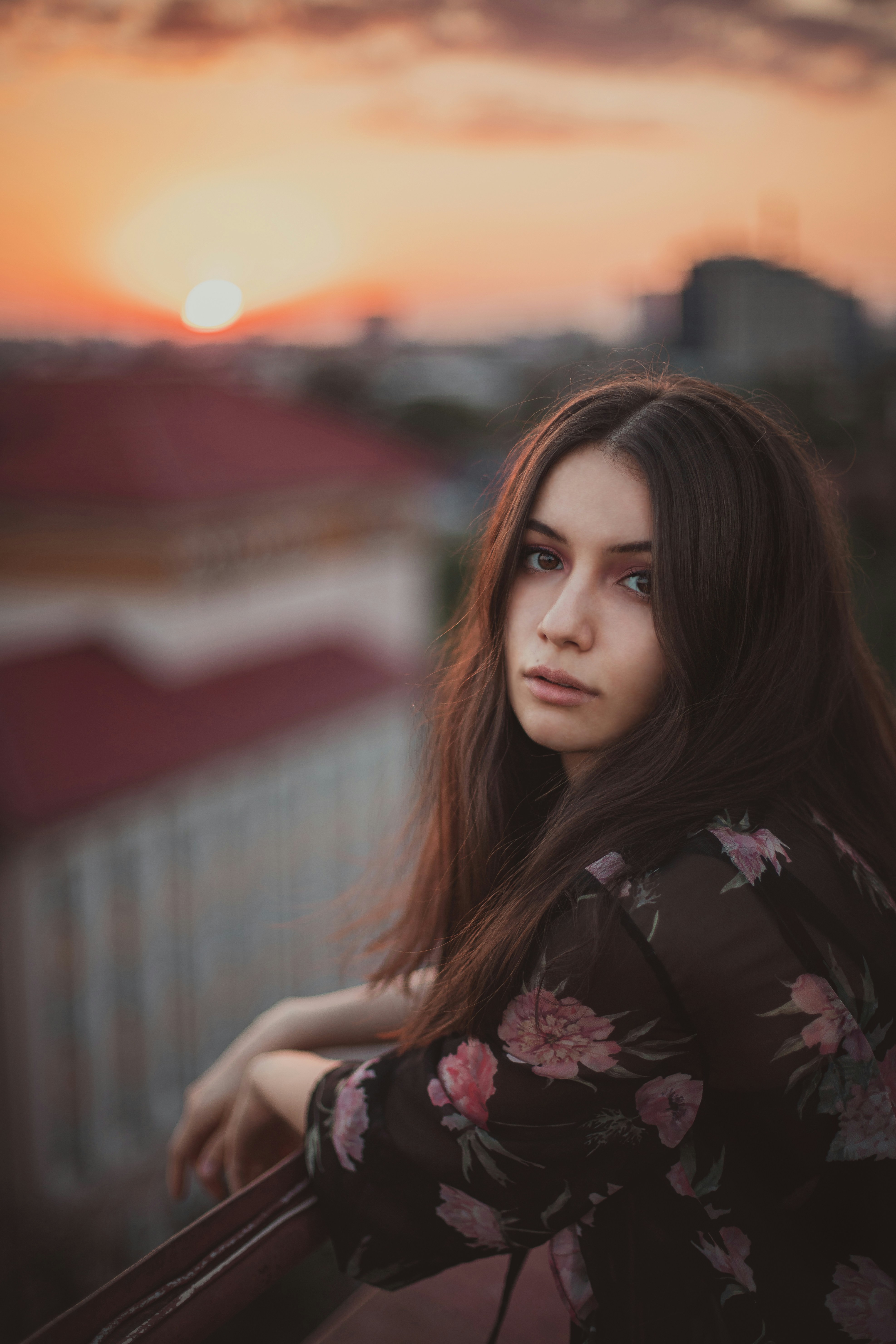 a woman with long hair standing on a balcony