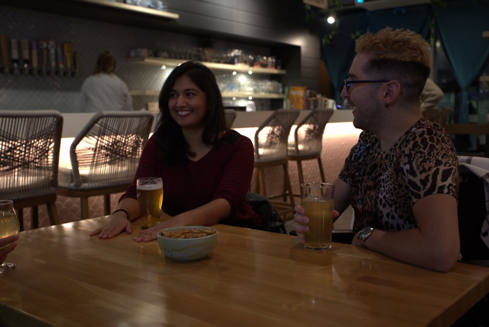 a man and a woman sitting at a table with drinks