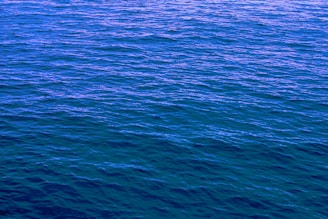 a large body of water with a boat in the distance