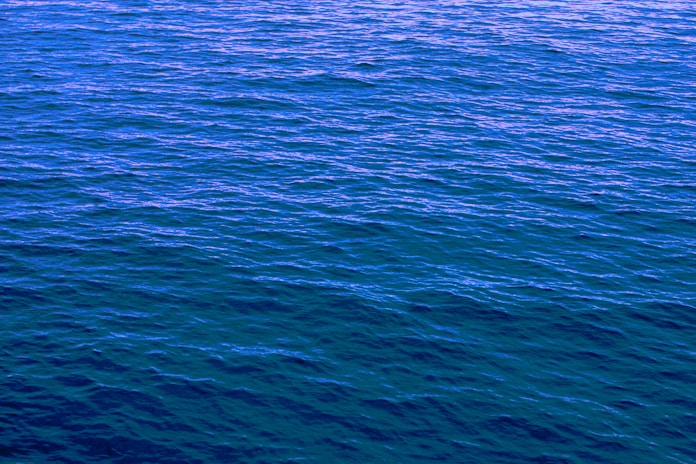 a large body of water with a boat in the distance