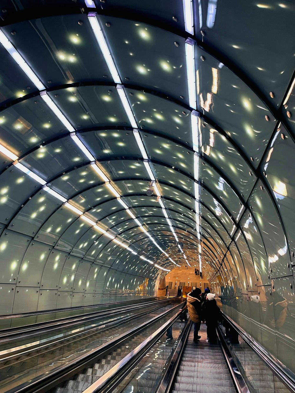 a subway station with people on the escalator