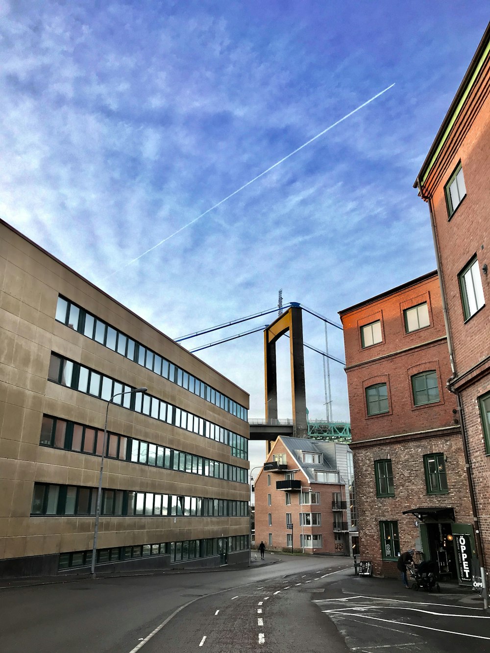 a city street with buildings and a bridge over it