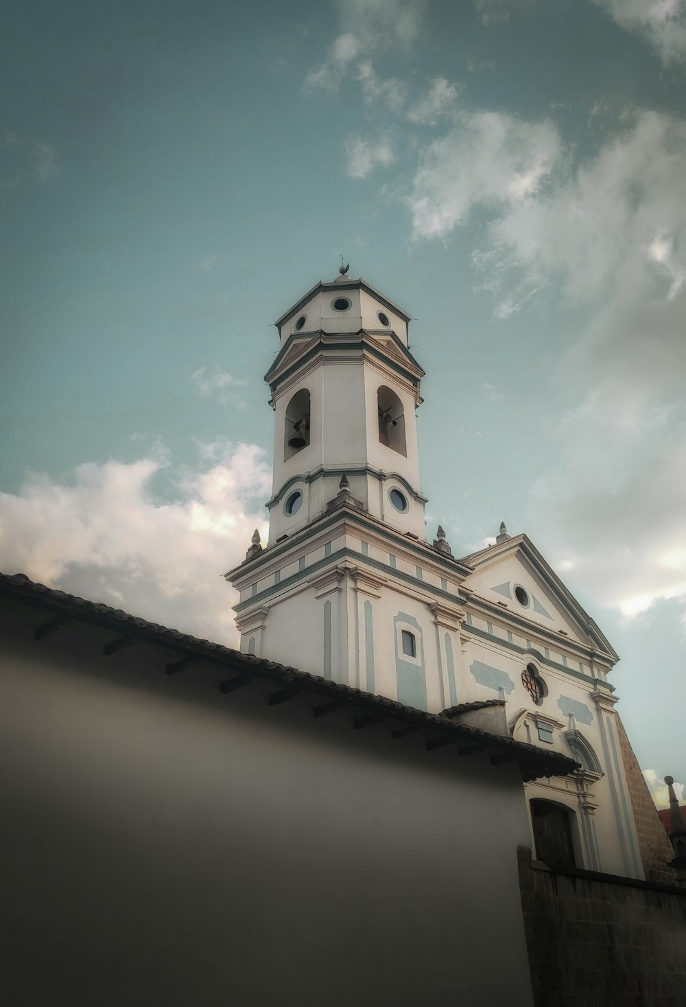 a tall white building with a clock on it's side