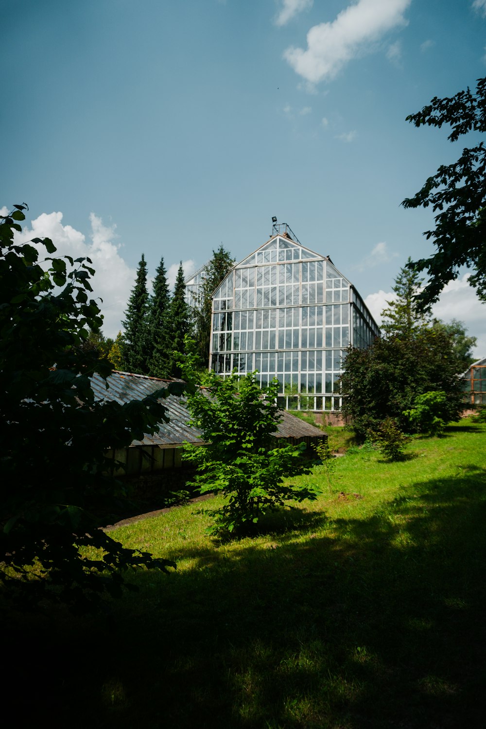 a large glass building sitting on top of a lush green field