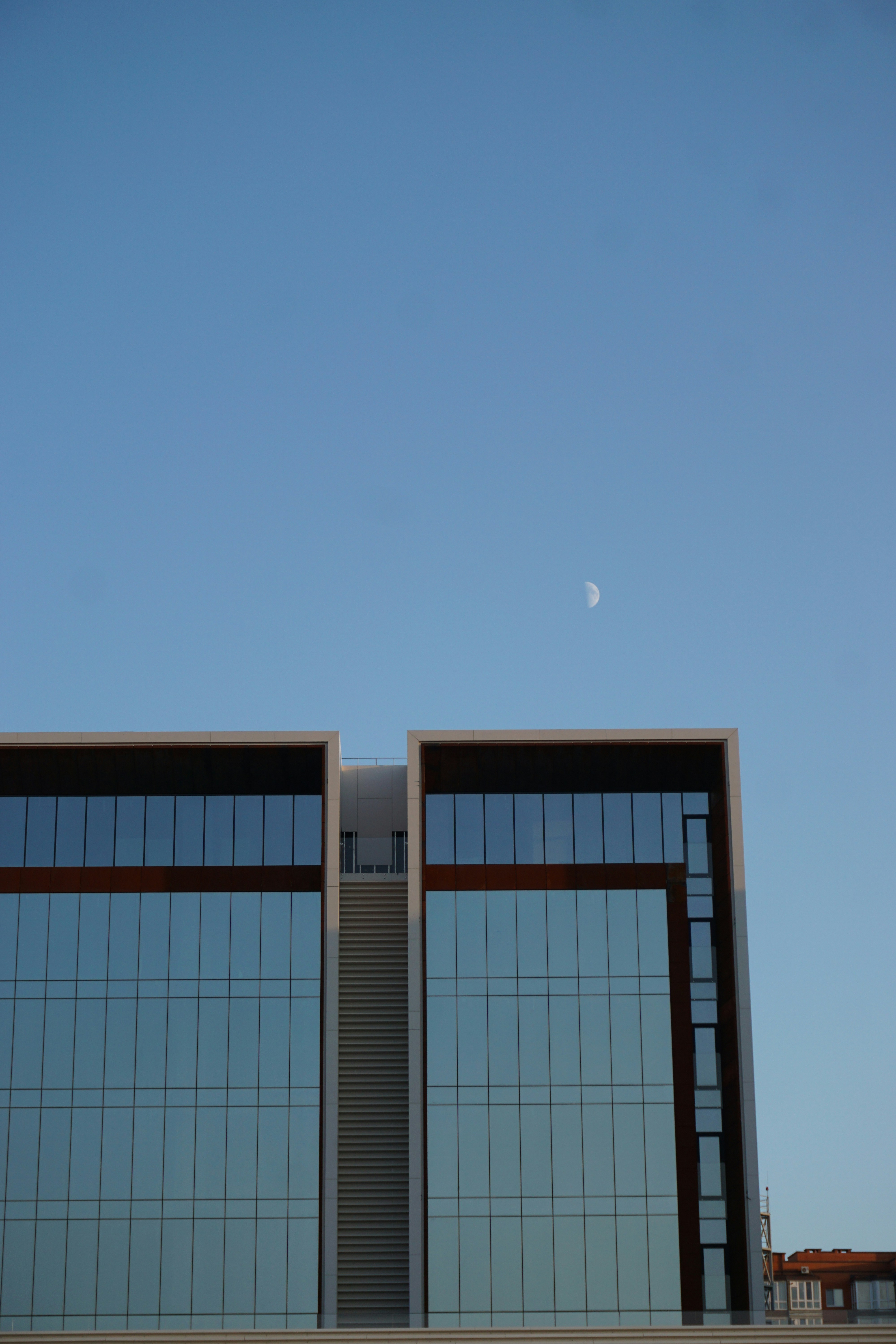 a tall building with a half moon in the sky