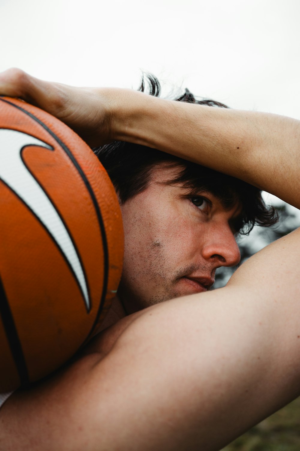 a man holding a basketball in his right arm
