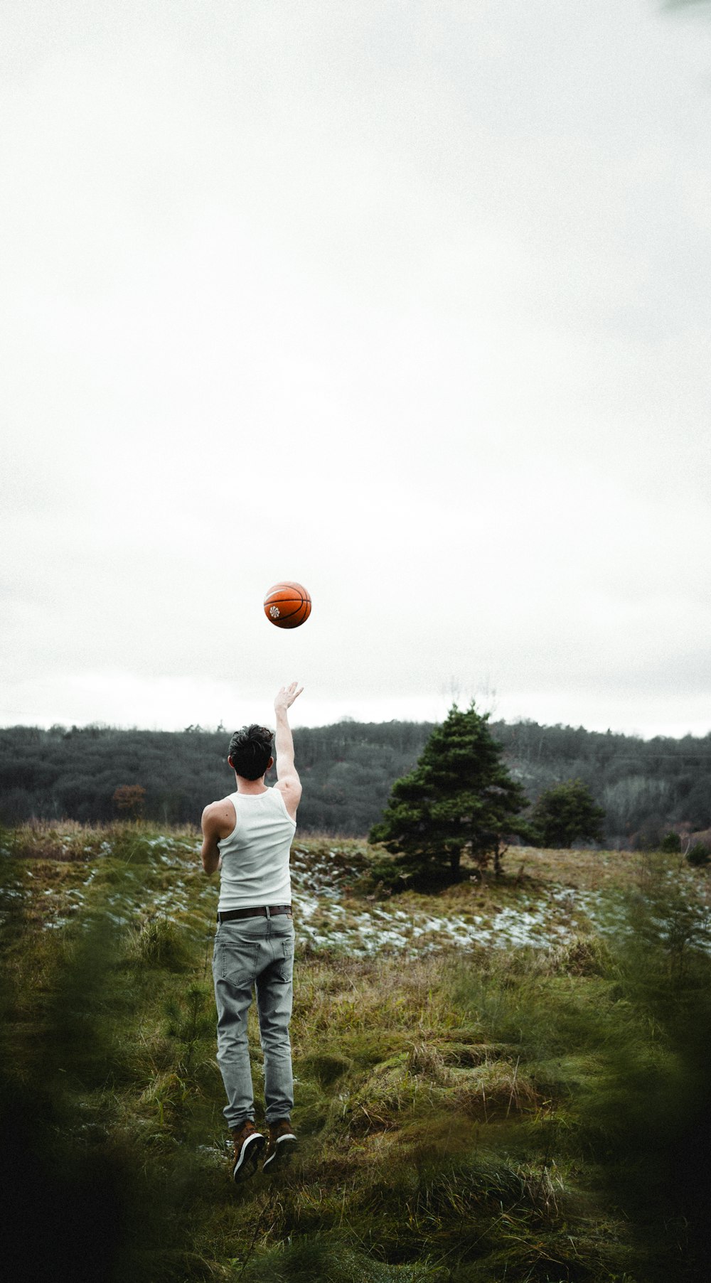 a man is playing with a basketball in a field