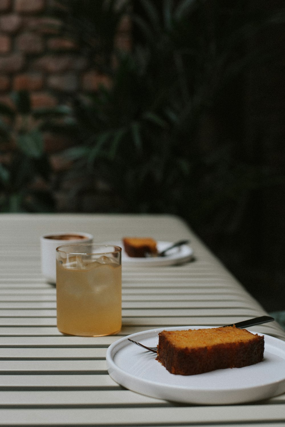 uma fatia de bolo sentada em um prato ao lado de uma bebida