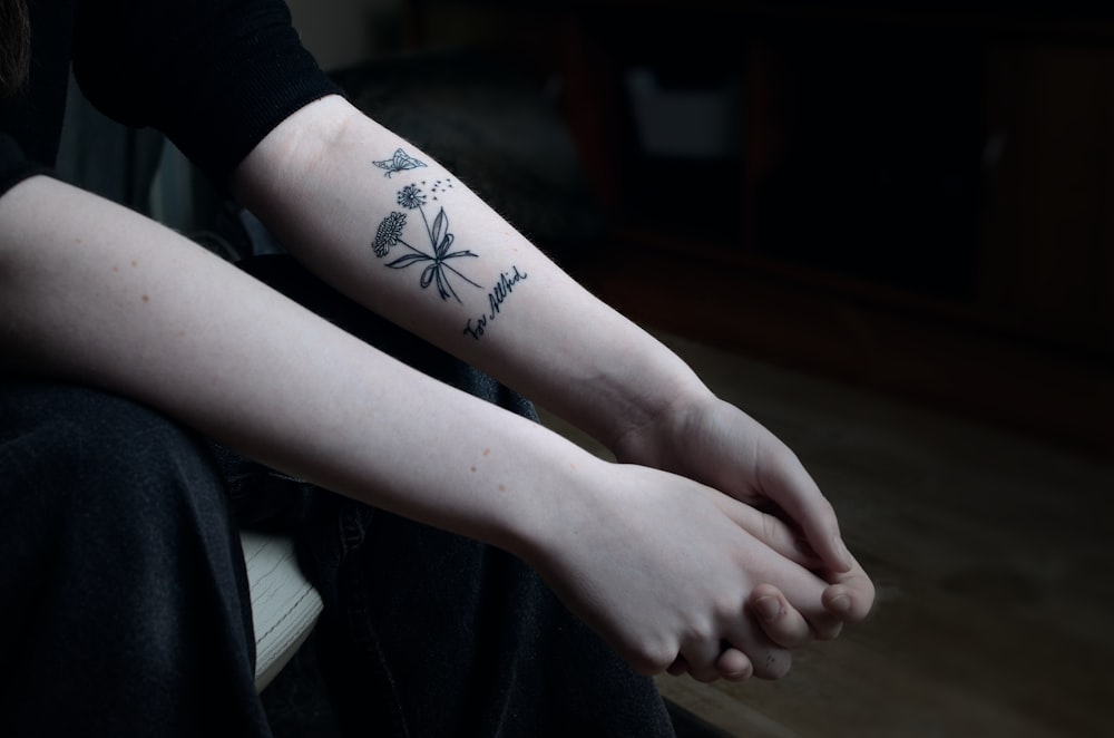 a person with a flower tattoo on their arm