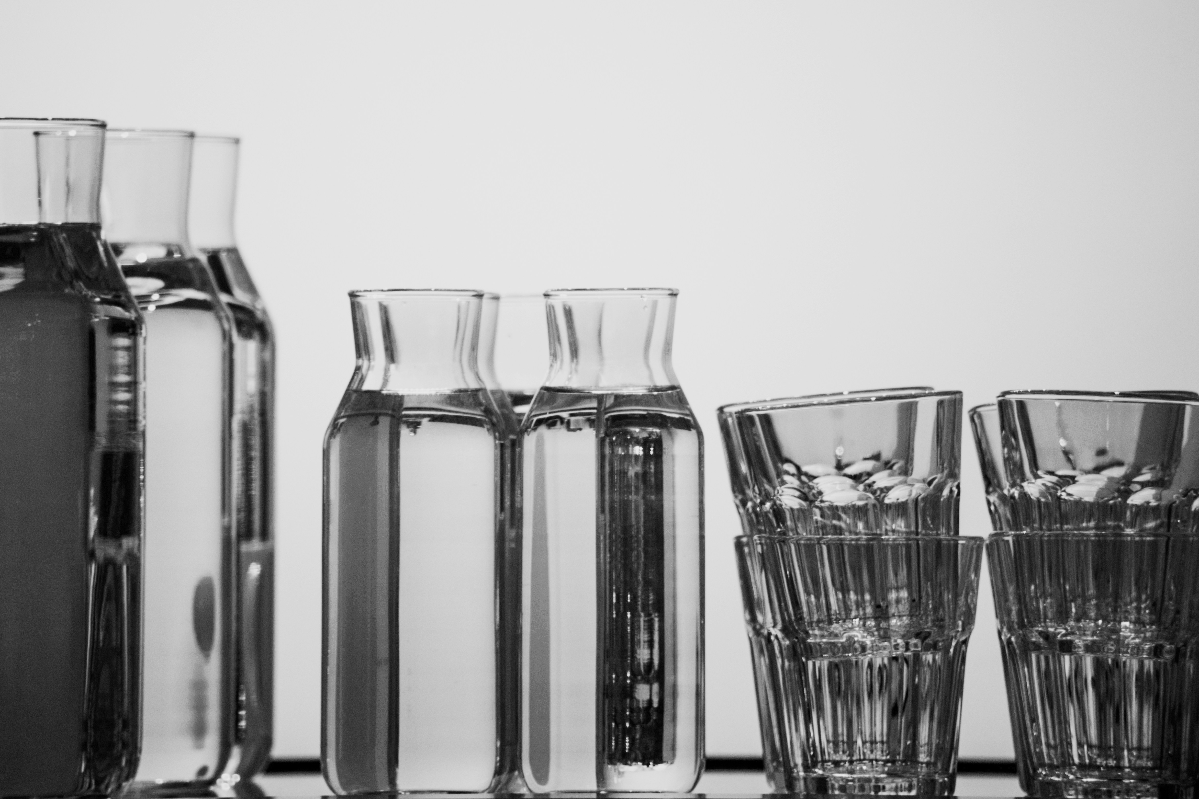 a table topped with glasses and vases filled with liquid